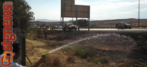 Cesar Flores continues to spray the ground by his home while firefighters mop up what’s left on the fire, Washington City, Utah, July 1, 2013 | Photo by Mori Kessler, St. George News