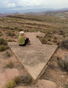 Mari Yunker enjoys the peaceful views from the Quail Creek Aviation Navigation Arrow. “It is a cool feeling knowing that you are sitting on a piece of aviation history right here in Washington County. Now I want to find all of them here,” she said. Beacon arrows were constructed between 1926-1928 to facilitate aviation navigation from Salt Lake City to Los Angeles. Washington County, Utah, Aug. 28, 2013 | Photo by John Teas, St. George News