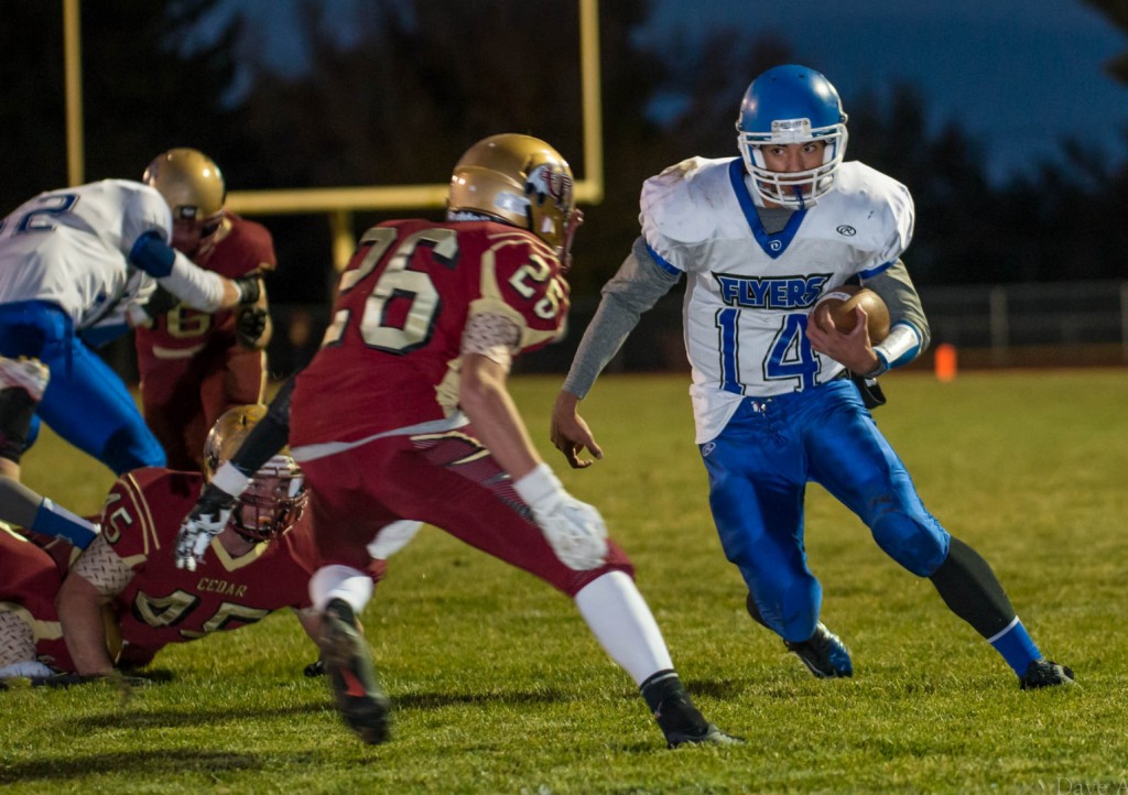 Ammon Takau (14) is pursued by Jeff Rogers (26), Dixie at Cedar, Cedar City, Utah, Oct. 16, 2013 | Photo by Dave Amodt, St. George News