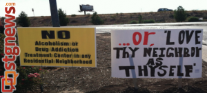 Signs both opposing and supporting a planned drug and alcohol treatment facility stand side-by-side at the Bloomington interchange. Aug. 9, 2013 | Photo by Samantha Aiken, St. George News