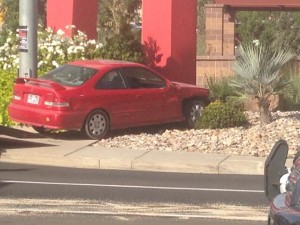 A red Honda Civic crashes into the Red Rock Commons sign after running a red light and being hit by an oncoming car, St. George, Utah, Oct. 23, 2014 |Photo by Holly Coombs, St. George News