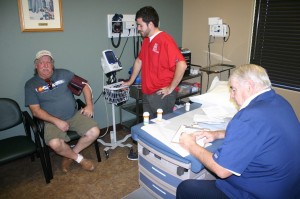 Don Furrow receives help from Tyler Argyle, an SUU health student, and Dr. Rox Burkett, MD. 