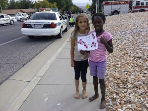 Emily and Jade pose with a thank you picture they designed and gave to the St. George police officers and St. George firefighters on scene at the intersection of 350 N. and 2450 East in St. George, Utah, Oct. 17, 2014 | Photo by Aspen Stoddard, St. George News