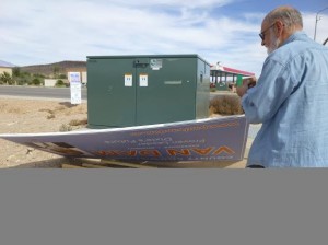 Paul Van Dam retrieves a campaign sign that was removed from the corner of 1450 S. River Road on Oct. 25, 2014 | Photo courtesy of Lisa Rutherford, St. George News