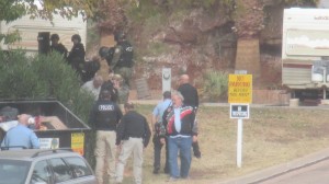 The suspect (gray shirt by the bushes) after surrendering to police. Bruce Solomon can be seen in the  jacket with the gray and red stripes, St. George, Utah, Dec. 2, 2014 | Photo by Mori Kessler, St. George News.