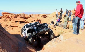 Bryce Thompson spotting for Richard Mick through a tight squeeze, Jan. 24, 2015 at Sand Hollow State Park | Photo by Leanna Bergeron, St. George News