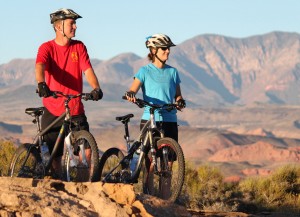 Couple taking a looking at a view as they ride mountain bikes, St. George, Utah, date unspecified | Image courtesy of Adventure Hub, St. George News