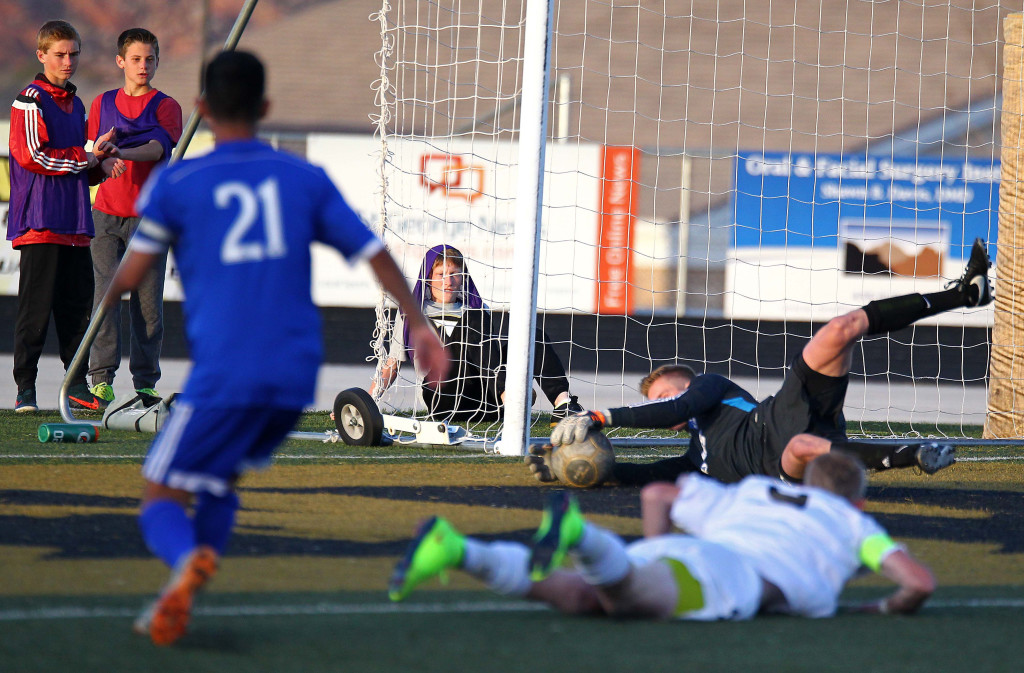 Desert Hills Trevor Browning fires a shot, Dixie goalie Ethan Poulton makes a diving save, file photo from Dixie vs. Desert Hills, Boys Soccer, St. George, Utah, Mar. 10, 2015 | Photo by Robert Hoppie, ASPpix.com, St. George News