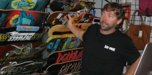 Kris Ripplinger, owner of Lip Trix in St. George, shows a selection of boards to a customer Friday morning | Photo by Ric Wayman, St. George News