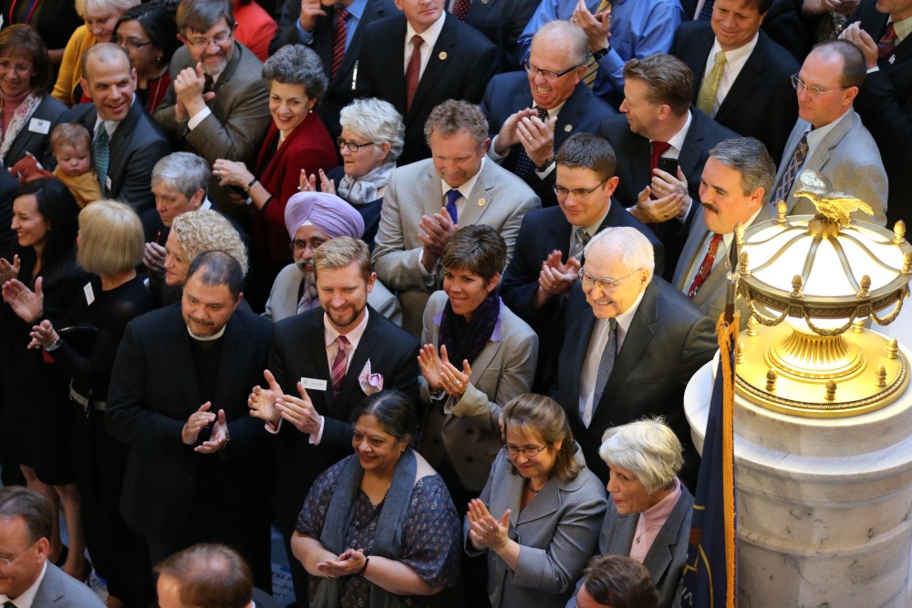 Elder L. Tom Perry of the Quorum of the Twelve Apostles (second row from the bottom, far right) joins other supporters and community leaders as Utah Senate Bill 296 is signed into law. Among them is Troy Williams, Equality Utah's executive director (second row, from the bottom, middle left), Salt Lake City, Utah, March 12, 2015 | Photo by Intellectual Reserve, Inc., courtesy of The Church of Jesus Christ of Latter-day Saints, St. George News