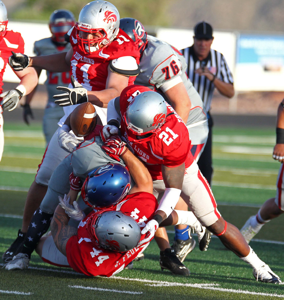 The Lions stack up a Revolution ball carrier as Brandon Thompson (21) strips the ball and recovers the fumble, Zion Lions vs. Wasatch Revolution, Football, St. George, Utah, Apr. 11, 2015 | Photo by Robert Hoppie, ASPpix.com, St. George News