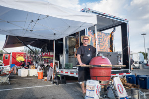 Scott "Manno"Manning, from Fort Collins, Colorado,  poses next to his barbecue equipment outside his trailer. 