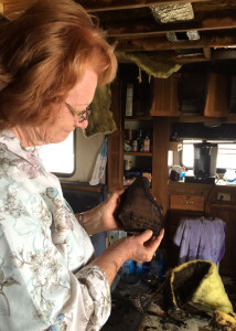 Homeowner examines the wreckage left behind from her mobile home fire, Foothills RV Subdivision, Parowan, Utah, May 12, 2015 | Photo by Carin Miller, St. George News