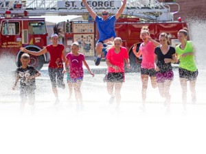 Racers run through the spray of a fire truck hose, location and date not specified | Photo courtesy of Fire Hose Frenzy, St. George News