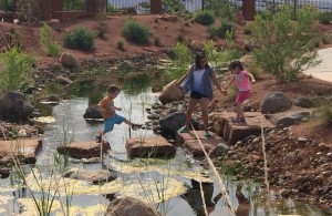 Right to left) 7-year-old Maxwell Kearl, along with 10-year-old Annabella Blackmer and 3-year-old Mia Blackmer, crossing the steam at the Red Hills Desert Garden, St. George, Utah, May 20, 2015 | Photo By Mori Kessler, St. George News