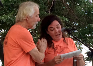 Groovefest Music and Art festival founder Tim Cretsinger places a reassuring hand on his wife Lisa Cretsinger's shoulder as she breaks down while reading his message to the crowd, Main Street Park, Cedar City, Utah, June 27, 2015 | Photo by Carin Miller, St. George News