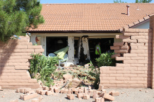 Damage to a brick wall and house after a Suzuki SX4 crashed into them, St. George, Utah, June 2, 2015 | Photo by Nataly Burdick, St. George News