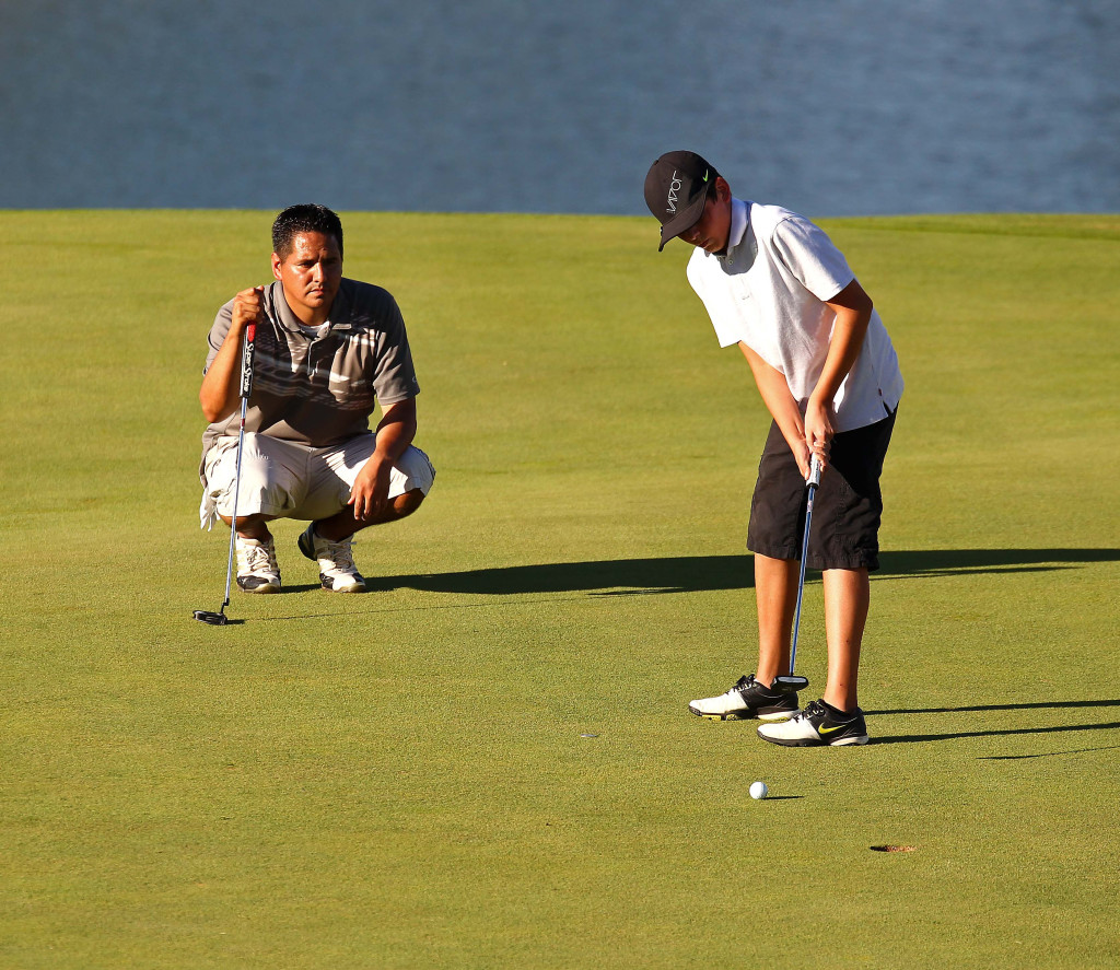 Jace Lee putts as his father Scott Lee watches, City of St. George JAG summer golf tournament, St. George, Utah, July 16, 2015, | Photo by Robert Hoppie, ASPpix.com, St. George News