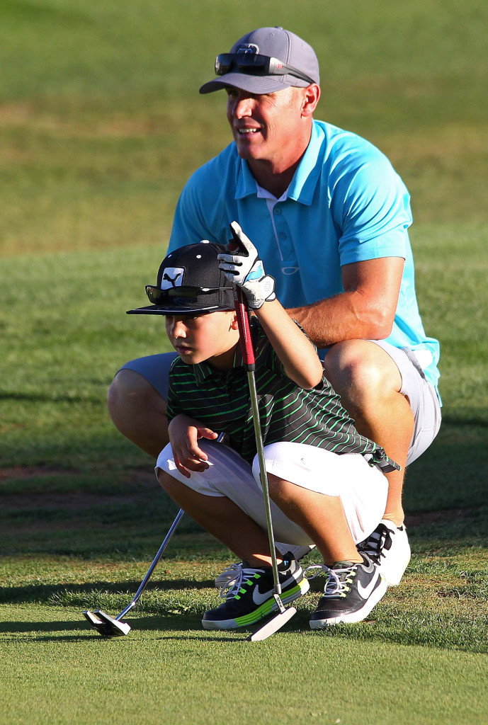 Ryan Filmore and his son Jace Filmore study the ninth green before putting, City of St. George JAG summer golf tournament, St. George, Utah, July 16, 2015, | Photo by Robert Hoppie, ASPpix.com, St. George News