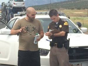 Alex Caballero, the driver of Semitrailer involved in a vehicle fire on northbound I-15 at milepost 48, discusses the details of the accident with Utah Highway Patrol Trooper Nathan Clark, Kanarravile, Utah, July 3, 2015 | Photo by Carin Miller, St. George News