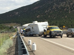 A tow truck prepares to tow away the remains of a trailer that flipped on I-15, spilling it's contents into the roadway, Washington County, milepost 36, July 6, 2015 | Photo by Devan Chavez, St. George News
