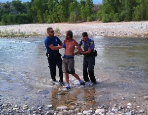 A Beaver Dam Fire captain and a Mohave County Sheriff's deputy escort Lawrence Jones to the ambulance for paramedic evaluation due to his intoxication, Littlefield, Arizona, July 18, 2015 | Photo courtesy of Mohave County Sheriff's Office, St. George News