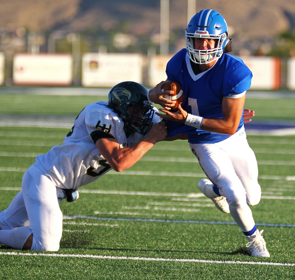 Dixie quarterback Zac Harrah (1) eludes a Mohave tackler, Dixie vs. Mohave Ariz. Football, St. George, Utah, Aug. 28, 2015, | Photo by Robert Hoppie, ASPpix.com, St. George News