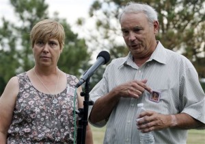 Robert and Sue Sullivan, whose 6-year-old granddaughter Veronica, whose picture is pinned to their chests, was killed in the theater shooting speak with the media outside Arapahoe County Courthouse after the jury failed to agree on whether James Holmes should get the death penalty, Centennial, Colo.,  Aug. 7, 2015 |  AP Photo by Brennan Linsey, St. George News 