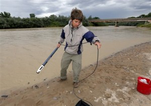 Ben Brown, with the Utah Department of Environmental Quality, takes a pH level reading from a probe in the San Juan River, in Montezuma Creek, Utah, Aug 11, 2015. A spill containing lead and arsenic from the abandoned Gold King Mine in Silverton, Colo., leaked into the Animas River, which flows into the San Juan River in southern Utah, on Aug. 5. The spill was caused by a mining and safety team working for the EPA, Montezuma Creek, Utah, Aug. 11, 2015 | AP Photo by Matt York, St. George News 