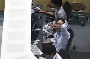 A worker of Tokyo Stock Exchange monitors stock prices on an electric screen during a trading session in Tokyo, Monday. Stocks tumbled across Asia on Monday as investors shaken by the sell-off last week on Wall Street unloaded shares in practically every sector, Tokyo, Japan, Aug. 24, 2015 | AP Photo by Koji Sasahara, St. George News