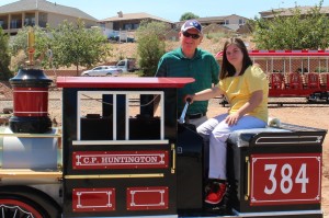 Amber Graves (sitting on the engine) and Kent Perkins, St. George Leisure Services Director, pose for photos, St. George, Utah, Aug. 17, 2015 | Photo by Mori Kessler, St. George News