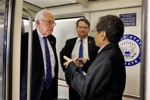 Democratic presidential candidate Sen. Bernie Sanders, I-Vt., left, is interviewed as he leaves after a Senate vote on Capitol Hill to approved a stopgap spending bill to avert a government shutdown. Sen. Gary Peters, D-Mich. is at center, Capitol Hill, Washington, Sept. 30, 2015 | AP Photo by Jacquelyn Martin, St. George News 