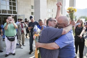 Michael Long, left, and Timothy Long kiss outside the Rowan County Judicial Center, raising their fist clinched high in to the air after being the second couple to receive a marriage license. Gay couples walked out of the Kentucky courthouse with marriage licenses Friday, a day after the county's defiant clerk, Kim Davis, was taken to jail for refusing to license same-sex marriages, citing "God's authority," Morehead, Ky, Sept. 4, 2015 | AP Photo by Alton Strupp, The Courier-Journal, St. George News