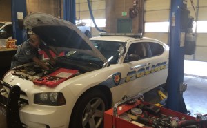 Fleet Services technician working one one the city's police cruisers. The city's Fleet technician outfit every cruiser with its lights, sirens and other systems, which can pack up to two miles wiring in each police vehicle, St. George, Utah, Sept. 3, 2015 | Photo by Mori Kessler, St. George News