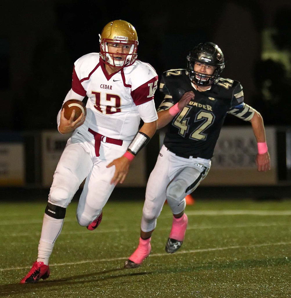 Cedar’s Mason Fakahua (12) runs away from Desert Hills' Tyler Warner (42), Cedar vs. Desert Hills, Football, St. George, Utah, Oct. 23, 2015, | Photo by Robert Hoppie, ASPpix.com, St. George News