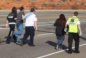 The driver of a white Nissan (second from left) involved in a head-on collision is helped to a private car for transport to the hospital, St. George, Utah, Oct. 20, 2015 | Photo by Ric Wayman, St. George News