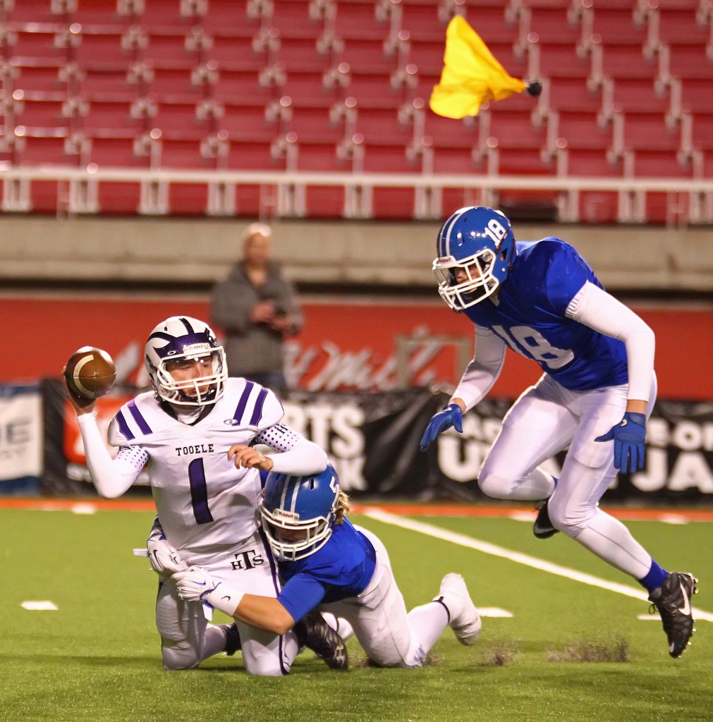 Dixie's  Cutler Thomas (5) sacks the Tooele quarterback as a penalty flag flies, Dixie vs. Tooele, 3AA Football Semifinals, Salt Lake City, Utah, Nov. 13th, 2015, | Photo by Robert Hoppie, ASPpix.com, St. George News