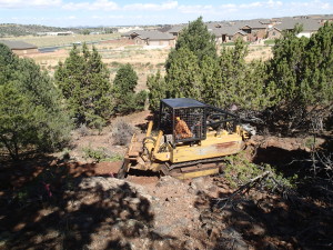 International Mountain Bike Association Trail Solutions employee Joey Klein clears a trail with the Utah State Parks Department trail dozer that was donated for the new Iron Hills Trail System, Cedar City, Utah, 2015 | Photo courtesy of Dave Jacobson, St. George News 