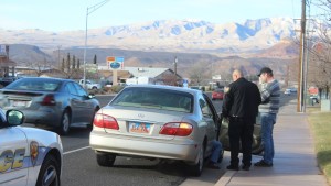 St. George Police Officer speaking with the driver and passenger of an Infiniti I30 involved in an accident on Sunset Blvd in St. George, Utah on December 28, 2015 | Photo by Don Gilman, St. George News