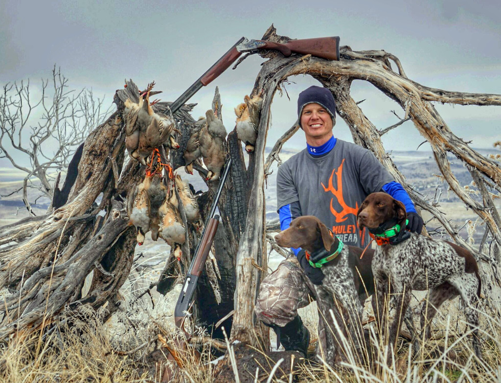 A hunter poses with his dogs and the chukars he caught, location and date unspecified | Photo courtesy of Clint Wirick, Utah Chukar and Wildlife Foundation, St. George News