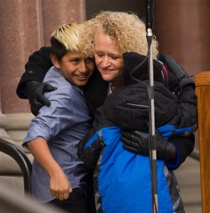 Jackie Biskupski hugs her sons Jack Iverson and Archie Biskupski following her remarks during the swearing-in ceremony. Biskupski was sworn in as Salt Lake City's first openly gay mayor. Salt Lake City, Jan. 4, 2016 | Photo courtesy of Scott G Winterton of The Deseret News via AP, St. George News