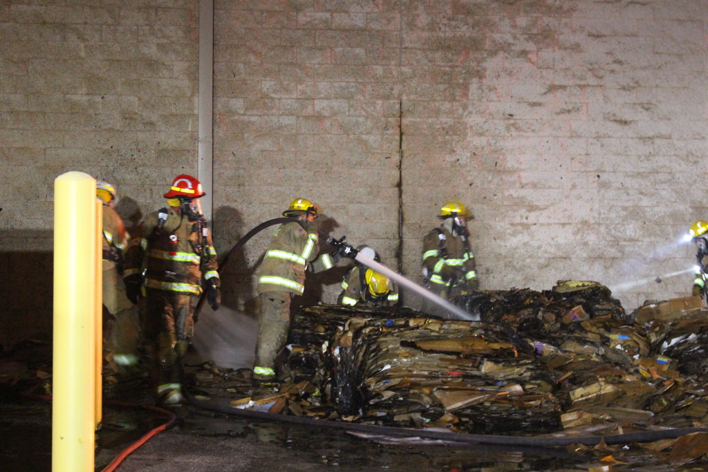 Firefighters break up cardboard to fully extinguish embers, Kmart, 745 S. Bluff St., St. George, Utah, Feb. 26, 2016| Photo by Cody Blowers, St. George News