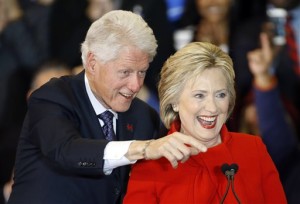 Former President Bill Clinton, left, and Democratic presidential candidate Hillary Clinton acknowledge supporters during a caucus night rally at Drake University, Des Moines, Iowa, Monday, Feb. 1, 2016. | AP Photo by Patrick Semansky, St. George News