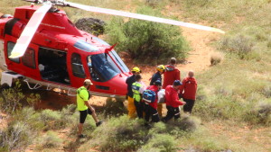 Rescuers carry an inured climber towards the waiting Life Flight helicopter at the base of the Cougar Cliffs in St. George, Utah, Mar. 12, 2016 | Photo by Don Gilman, St. George News