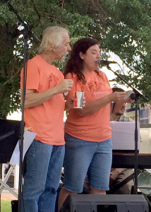 Groovefest founder Lisa Cretsinger reads a hand-written letter to the audience from her husband Tim Cretsinger who is unable to read it himself, because of a massive tumor in his throat that he is undergoing treatments for. Tim Cretsinger's treatments began Monday, the first day of the week-long music festival, Main Street Park, Cedar City, Utah, June 27, 2015 | Photo by Carin Miller, St. George News