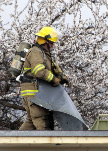 Firefighter Travis Topham tears apart the roof to access hot spots, 260 E. 400 North, Cedar City, Utah, March 22, 2016 | Photo by Carin Miller, St. George News