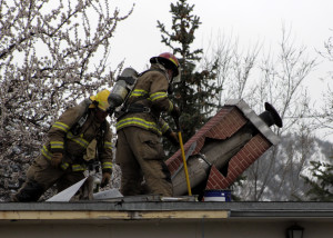 Battalion Chief Matt Gale and Firefighter Travis Topham tear apart the roof to access hot spots, 260 E. 400 North, Cedar City, Utah, March 22, 2016 | Photo by Carin Miller, St. George News