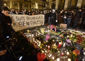 People holding a banner reading "I am Brussels" behind flowers and candles to mourn for the victims at Place de la Bourse in the center of Brussels, Tuesday, March 22, 2016. Bombs exploded at the Brussels airport and one of the city's metro stations Tuesday, killing and wounding scores of people, as a European capital was again locked down amid heightened security threats, Brussels, Belgium, March 22, 2016 | AP Photo/Martin Meissner. St. George News 