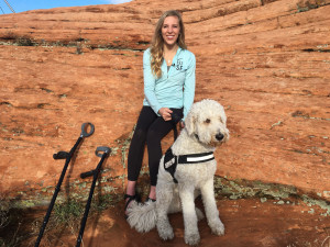 Brittany Fisher arrives with her companion dog, a golden doodle, Cooper, at Cougar Cliffs. Fisher suffered serious injuries when she fell from the rocks while there on a rappelling excursion March 12, 2012. Four years later she returned to rappel the cliffs again with the help of the high angle rope rescue team. Cougar Cliffs area of Washington County, Utah, March 12, 2016 | Photo by Rick Graf, St. George News 