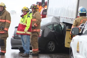 Emergency responders tended to an accident scene on southbound Interstate 15 Saturday. A woman driving a Toyota Prius lost control, hitting the center divider and then careening back into traffic, where the car embedded itself under a semitrailer. Washington County, Utah, April 9, 2016 | Photo by Ric Wayman, St. George News